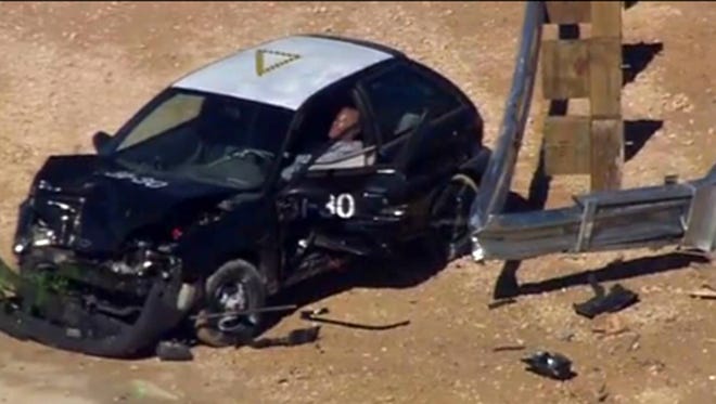 A small car sits mangled after a crash test for the Trinity ET Plus guardrail end terminal