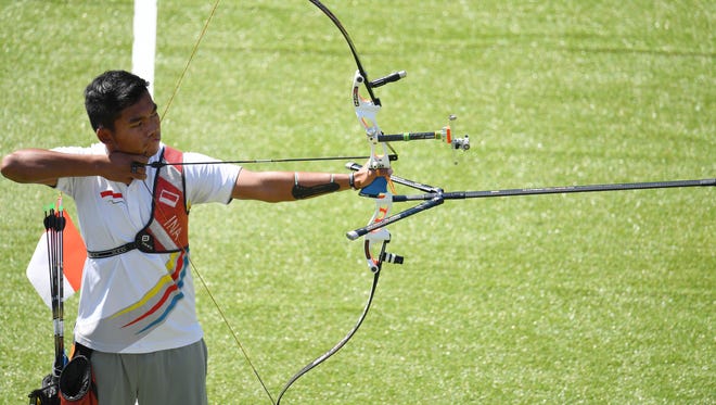 Hendra Purnama of Indonesia takes aim during the men's archery team 1/8 eliminations at Sambodromo.