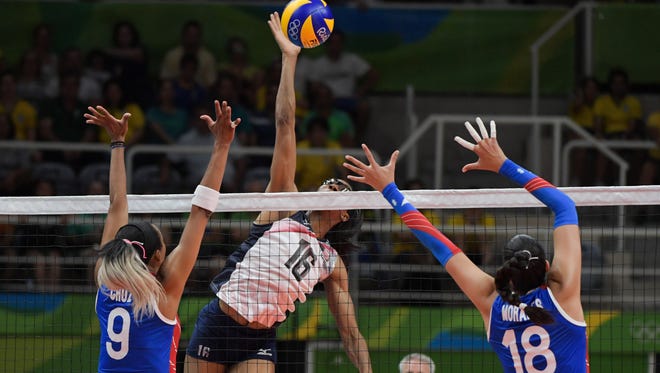 Team USA middle blocker Foluke Akinradewo (16) plays the ball to Puerto Rico weak side hitter Aurea Cruz (9) and middle blocker Lynda Morales (18) during a match in the preliminary round in the Rio 2016 Summer Olympic Games at Maracanazinho.