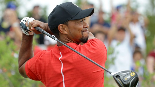 Tiger Woods watches his tee shot on the first hole during the final round.