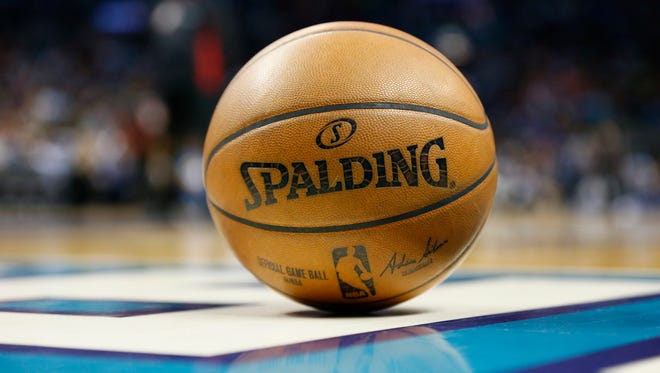 A basketball lays on the court during a timeout in the game between the Charlotte Hornets and the Phoenix Suns at Spectrum Center.