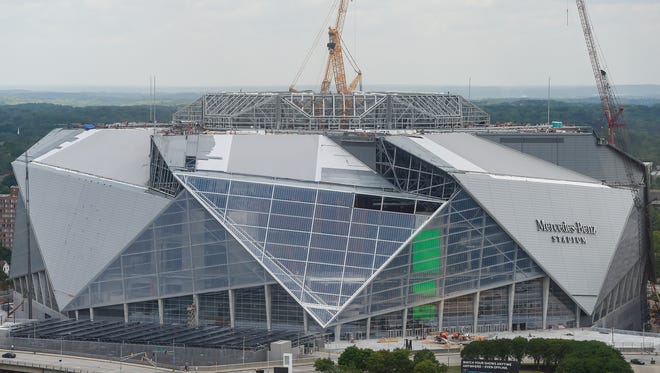 FILE -In this Tuesday, April 18, 2017 file photo, large cranes loom over the construction at the new Mercedes Benz Stadium, in Atlanta. The planned opening of the $1.5 billion stadium has been delayed. Stadium general manager Scott Jenkins told The Associated Press on Tuesday, April 25, 2017,  that the building is 90 percent done, but the biggest holdup has been roof construction. (AP Photo/Mike Stewart, File) ORG XMIT: GAMS201