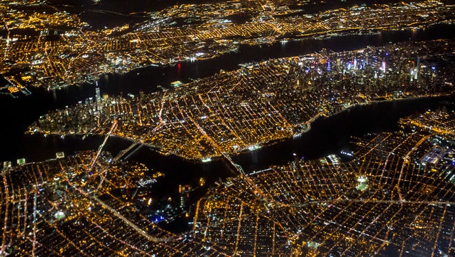 The island of Manhattan radiates light as a Delta flight passes overhead, due to land at New York's JFK Airport.