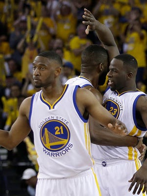 Golden State Warriors guard Ian Clark, from left, center Festus Ezeli and forward Draymond Green react after scoring against the Portland Trail Blazers during the second half in Game 2 of a second-round NBA basketball playoff series in Oakland, Calif., Tuesday, May 3, 2016.