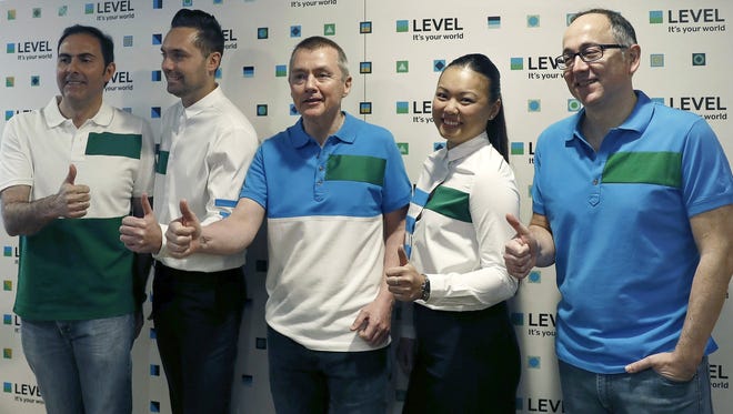IAG group CEO Willie Walsh (center) gives a thumbs-up at a press event launching the new low-cost airline 'Level' in Barcelona on March 17, 2017.