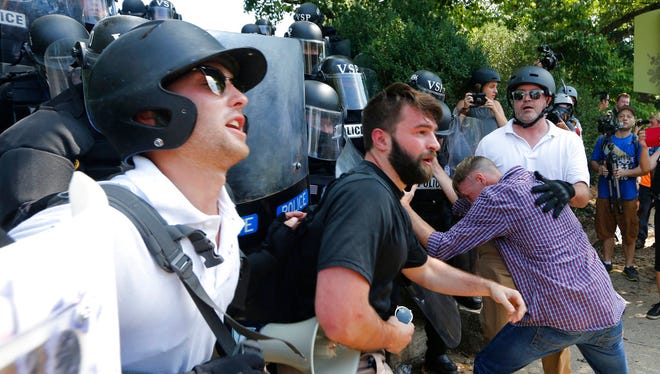 White nationalist demonstrators clash with police at the entrance to Lee Park in Charlottesville, Va., Saturday, Aug. 12, 2017.  Gov. Terry McAuliffe declared a state of emergency and police dressed in riot gear ordered people to disperse after chaotic violent clashes between white nationalists and counter protestors. (AP Photo/Steve Helber)