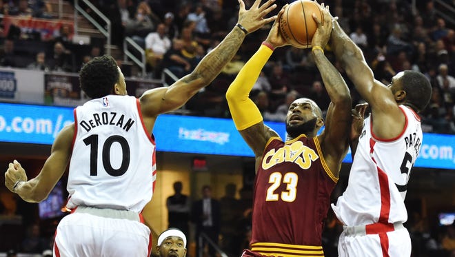 Cleveland Cavaliers forward LeBron James (23) shoots as Toronto Raptors guard DeMar DeRozan (10) and forward Patrick Patterson (54) defend during the second quarter at Quicken Loans Arena.