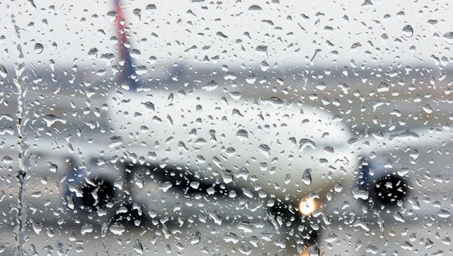 Raindrops fill a window pane during a dreary day at New York's JFK Airport.