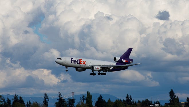 A FedEx DC-10 prepares to land in Seattle under enormous clouds.