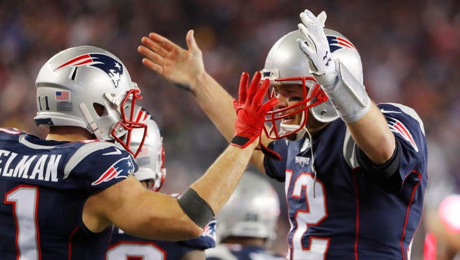 Patriots quarterback Tom Brady (12) celebrates a touchdown pass to wide receiver Julian Edelman (11) during the third quarter.