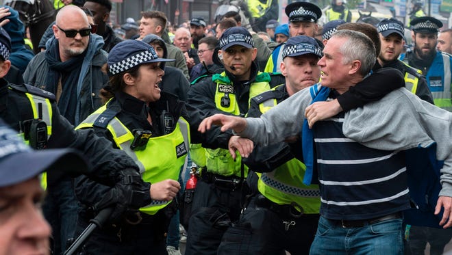 Police intervene in clashes between Arsenal and Tottenham fans.