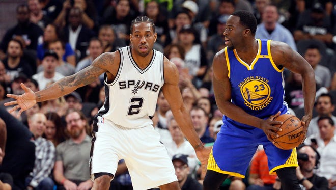 Golden State Warriors power forward Draymond Green (23) looks to pass the ball as San Antonio Spurs small forward Kawhi Leonard (2) defends during the first half at AT&T Center.
