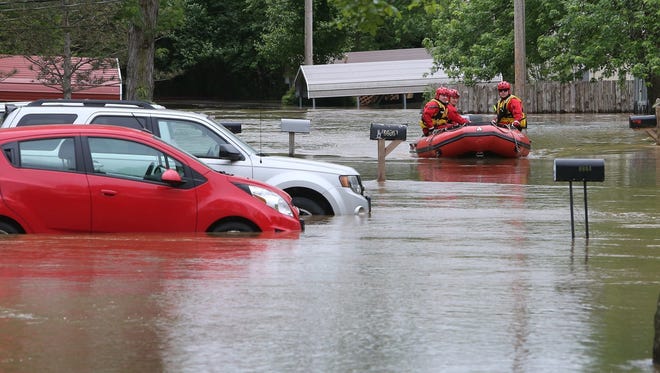 Members of the High Ridge fire department take a boat in at the Village Green Estates trailer park on May 1, 2017, in Cedar Hill, Mo. Torrential rains over the weekend caused flash flooding across Missouri, and as storm drains and fields continue to pour into rivers, they continue to rise.
