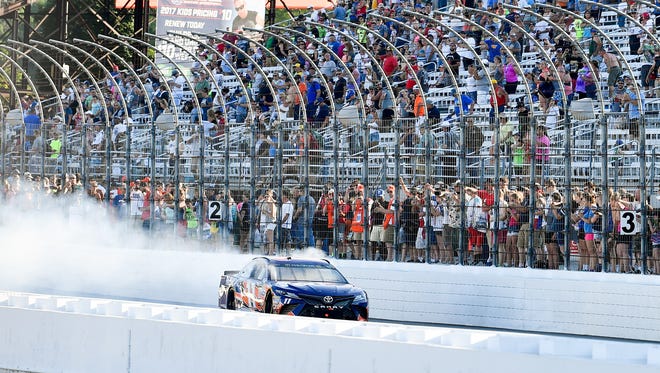 Denny Hamlin does an extra-long burnout to celebrate snapping a 28-race losing streak, at New Hampshire Motor Speedway on July 16.
