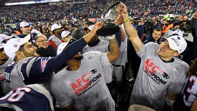 The New England Patriots celebrate with the Lamar Hunt Trophy after beating the Steelers.
