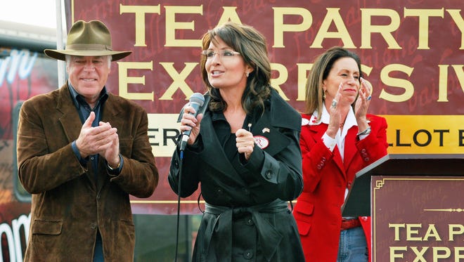 Palin campaigns for U.S. Senate candidate John Raese as his wife, Liz, applauds, on Oct. 30, 2010, in Wheeling, W.Va.