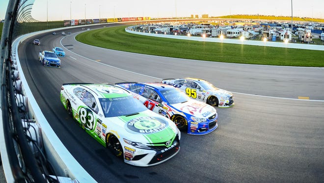 Corey LaJoie (83), AJ Allmendinger (47) and Michael McDowell (95) go three-wide through Turn 1 during the Go Bowling 400 at Kansas Speedway on May 13. Martin Truex Jr. won.
