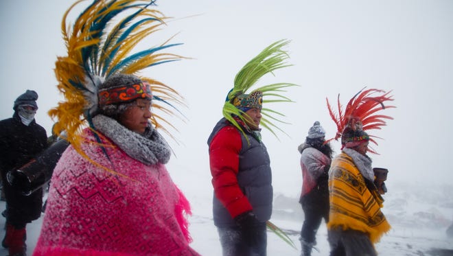 Native dancers return to camp after marching with veterans to the highway 1806 bridge north of the Oceti Sakowin Camp on Monday, Dec. 5, 2016 near Cannon Ball. Officials had been staffing the bridge full time but have said they are going to cut back.
