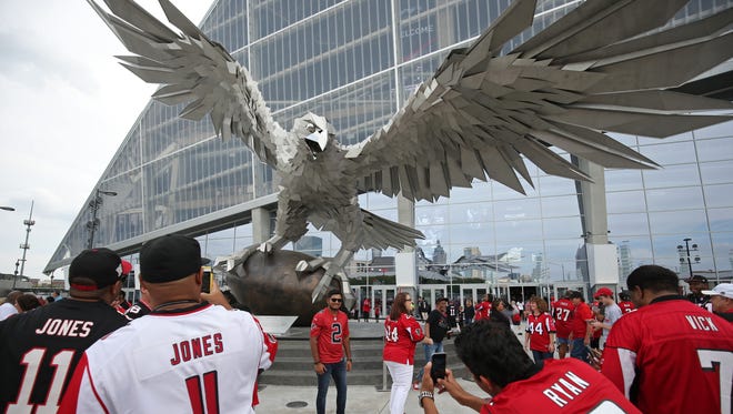 Atlanta Falcons fans take photographs in front of the Falcon statue before the Atlanta Falcons' first  game at Mercedes-Benz Stadium.