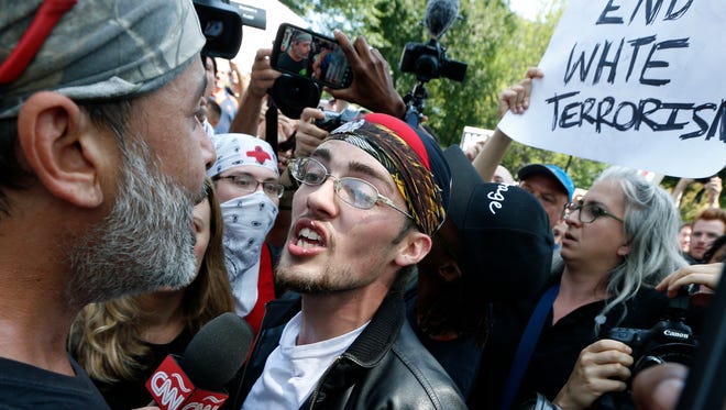 A professed supporter of President Donald Trump, center, argues with a counter-protester, left, at a "Free Speech" rally by conservative activists on Boston Common, in Boston.