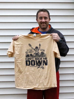Will Condon holds up the T-shirt that was sold by the Corning-Painted Post football program to raise more than $5,000 toward the costs of his medical care.