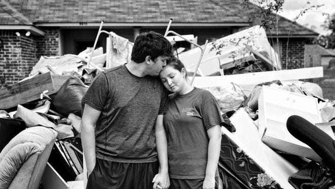 Brandon comforts his wife Dara, both have had an incredible outlook despite losing their business and home. Brandon jokingly placed a garage sale sign in front of all of their belongings, finding humor in the worst of situations. Denham Springs, LA.