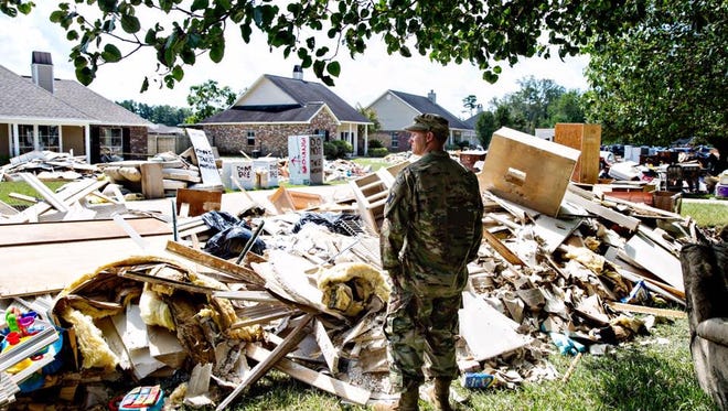Chris Daves, a National Guardsman, surveys the damage from a friend's yard. He's there to help and listen, "We're fellow armyman, that's what we do." Watson, LA.