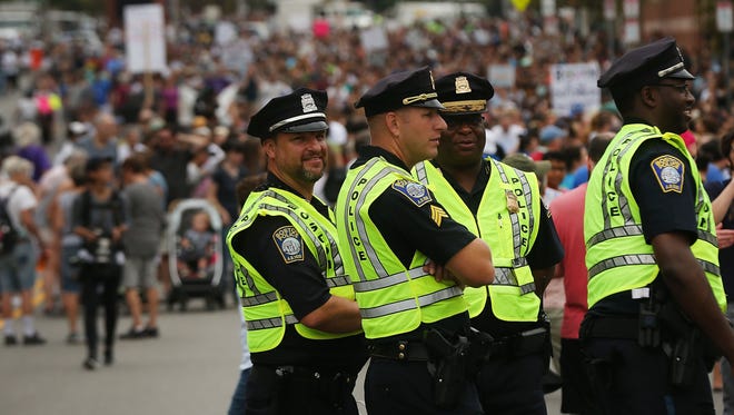 Police stand by as thousands of protesters prepare to march in Boston against a planned free speech rally.