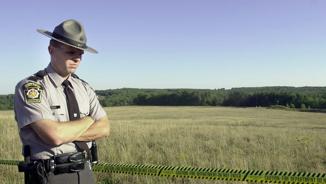 A Pennsylvania State Trooper stands guard at the crash site of United Airlines Flight 93 near Shanksville, Pa., on Sept. 11, 2001.