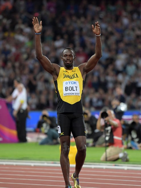 Usain Bolt of Jamaica wins his heat in the first round of the 100.