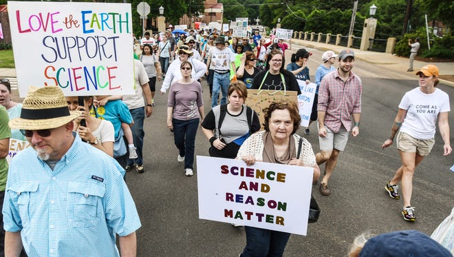 Participants in a March for Science walk from the University of Mississippi to the Square in Oxford, Miss.