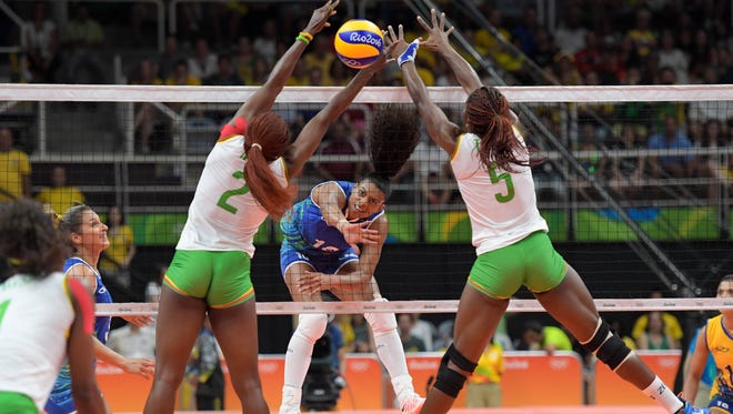 Brazil weak side hitter Gabriela Braga Guimaraes (10) plays the ball while guarded by Cameroon outside hitter Christelle Tchoudjang Nana (2) and middle blocker Theorine Christelle Aboa Mbeza (5) during their game in the preliminary round in the Rio 2016 Summer Olympic Games at Maracanazinho.