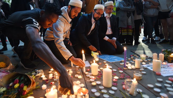 People light candles at a vigil for the people who lost their lives during the Manchester terror attack.