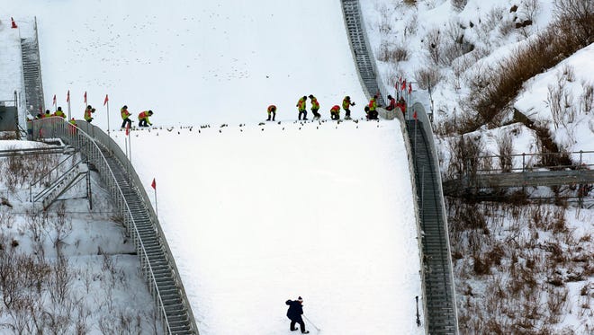 Slope assistants mark the route in the Alpensia Ski Jumping Stadium, which will host several events during the 2018 Winter Olympics, in Pyeongchang, South Korea, on Feb. 1.