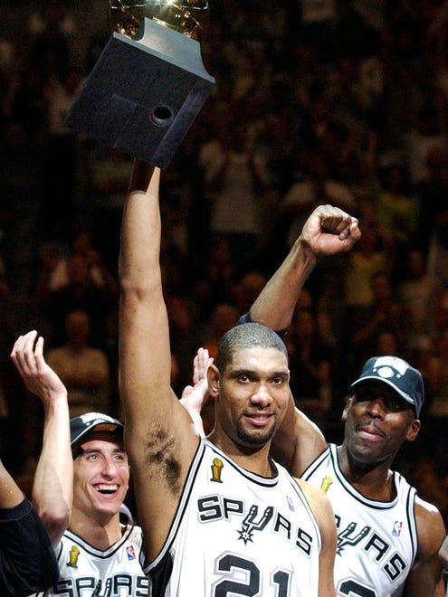 2003: Tim Duncan, Ginobili and Kevin Willis celebrate after the Spurs defeated the New Jersey Nets 88-77 to win the NBA Championship.