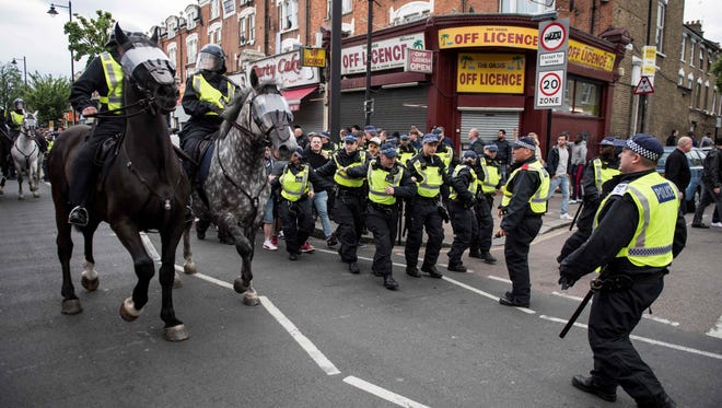 Police prepare to intervene in clashes between Arsenal and Tottenham fans.