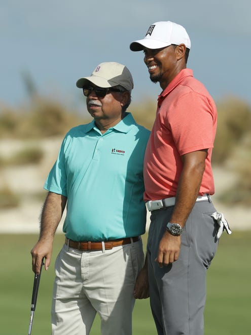 Tiger Woods poses with Pawan Munjal, CEO of Hero MotoCorp, after playing in the Pro-Am at the Hero World Challenge.