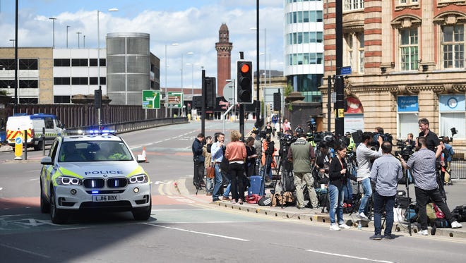 Members of the media gather at a police cordon close to the Manchester Arena following a deadly terror attack at the Ariana Grande concert at the Manchester Arena the night before. Twenty two people have been killed and dozens injured in Britain's deadliest terror attack in over a decade after a suspected suicide bomber targeted fans leaving a concert of US singer Ariana Grande.