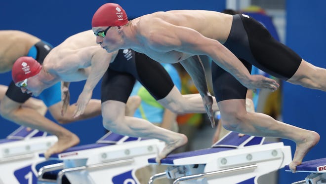 Adam Peaty and Ross Murdoch of Great Britain dive at the start of the men's 100 meter breaststroke heats during the Rio 2016 Summer Olympic Games at Olympic Aquatics Stadium.