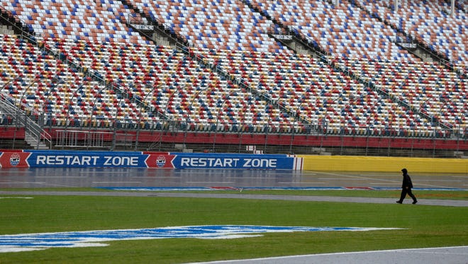 A security guard walks across the track at Charlotte Motor Speedway in Charlotte, N.C., Friday, Oct. 7, 2016.