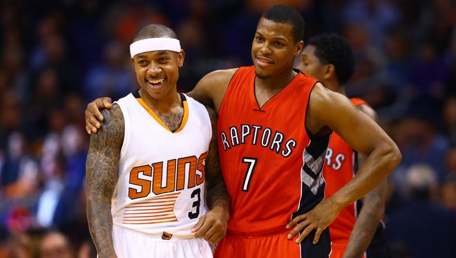 Jan. 4, 2015: Kyle Lowry (7) embraces Phoenix Suns guard Isaiah Thomas (3) during a second quarter time out at US Airways Center.