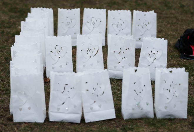 Luminaries spell the letter E during the vigil held for three-year-old Elijah Vue at Walsh Field, Saturday, March 16, 2024, in Two Rivers, Wis.