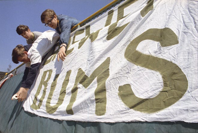 Fans tape down a sign in the outfield that says "Brewer bums" during the Brewers' first opening day on April 7, 1970. The game was also the season opener for the Brewers. A crowd of 37,237 saw the Brewers fall to the California Angels 12-0.