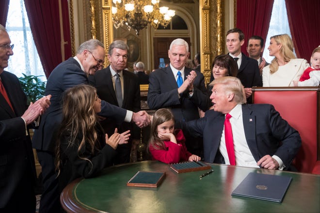 President Trump shakes hands with Senate Minority Leader Chuck Schumer as he is joined by congressional leadership and his family while he formally signs his Cabinet nominations into law in the President?s Room of the Senate on Jan. 20, 2017.