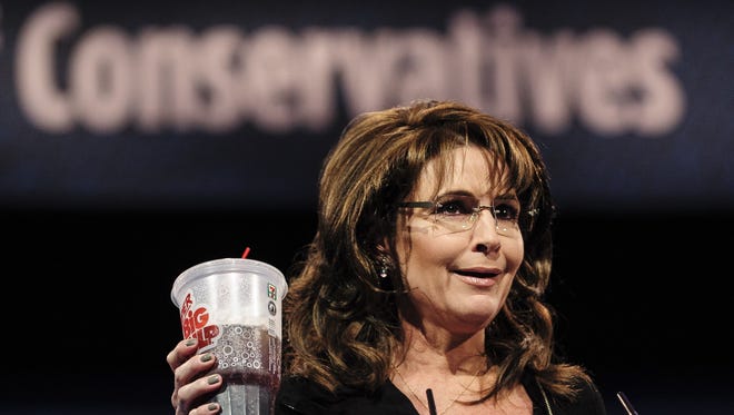 Former Alaska Gov. Sarah Palin holds up a cup as she speaks Saturday about New York City Mayor Michael Bloomberg's proposed large soda ban. She spoke at the 2013 Conservative Political Action Conference in Oxon Hill, Md.