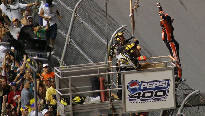 Stewart (right) celebrates atop the flag stand near fans at Daytona International Speedway after winning the 2005 Pepsi 400.  According to National Motorsports Press Association (NMPA), Stewart is one of the Top 10 most popular drivers in NASCAR.