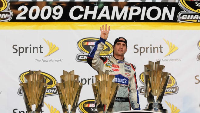 Jimmie Johnson poses with four trophies on Nov. 22, 2009 after winning the Sprint Cup championship for the fourth consecutive year.